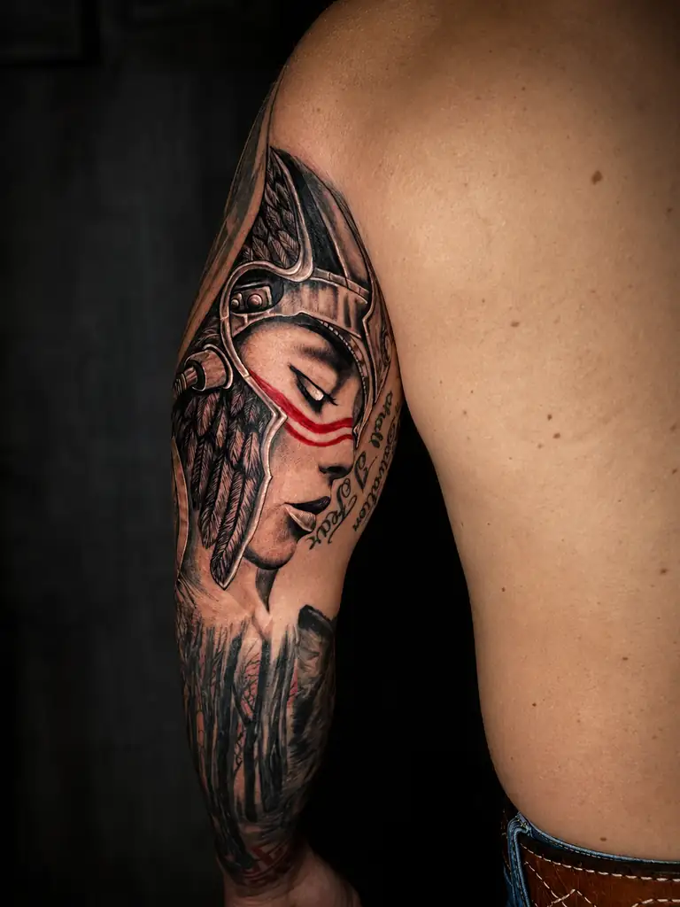Black and grey realism warrior portrait tattoo on the upper arm.